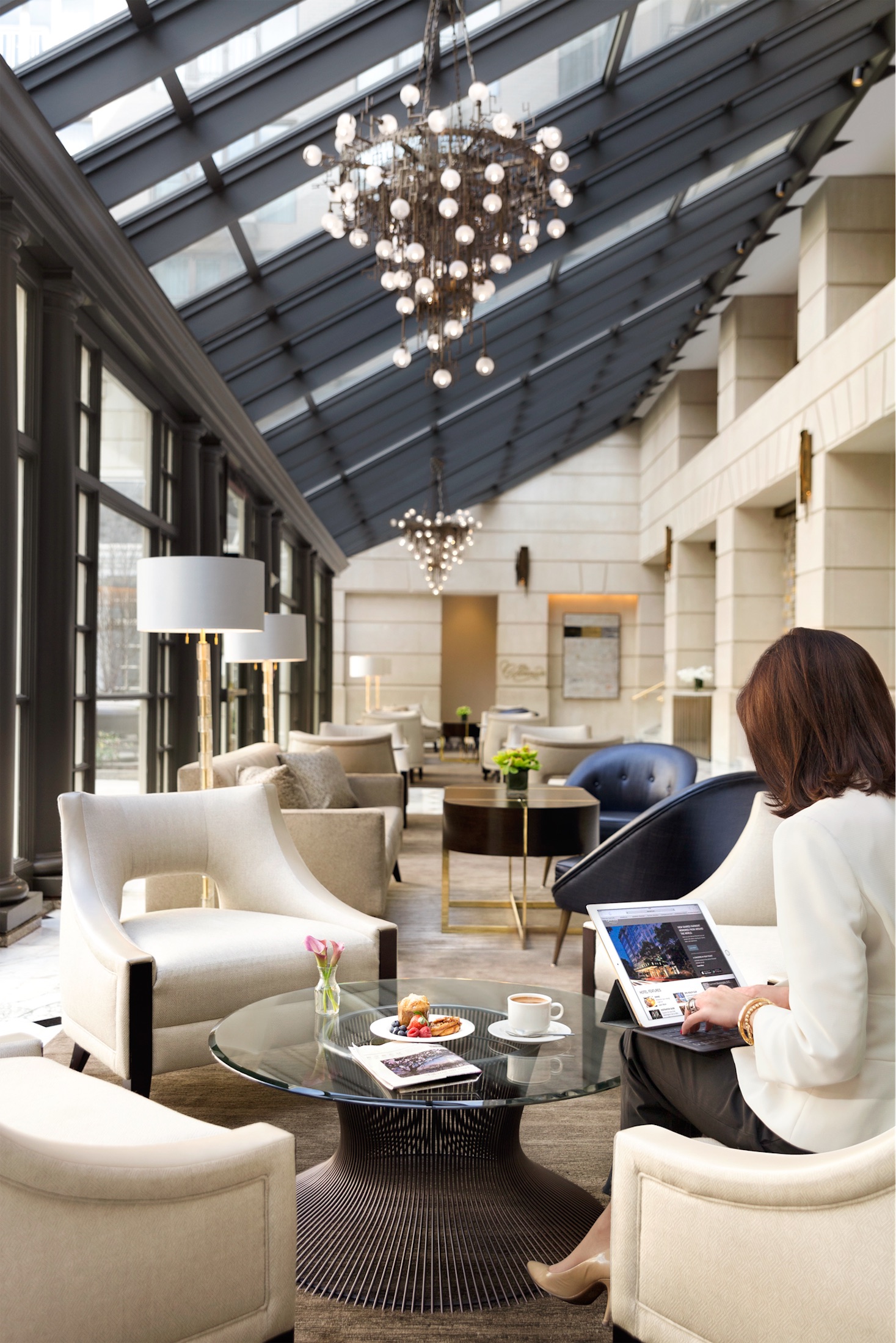 A woman on a iPad in a hotel lobby lounge