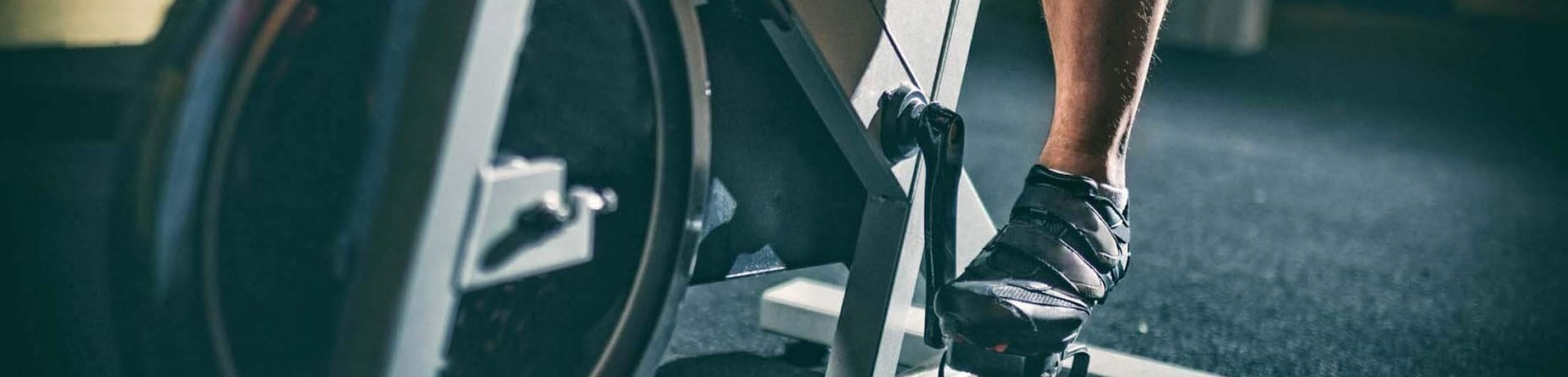 The lower half of a person on a stationary bike.